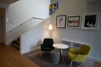 a room with a table and two chairs and a staircase at Holiday Inn Preston by IHG in Preston