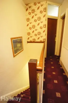 a hallway with a stairway with a painting on the wall at Fairhaven Holiday Flats in Blackpool