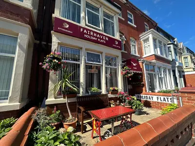 a cafe with a table in front of a building at Fairhaven Holiday Flats in Blackpool