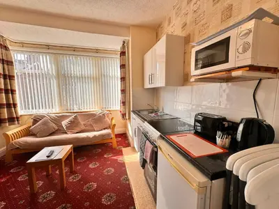 a small kitchen with a couch in a room at Fairhaven Holiday Flats in Blackpool