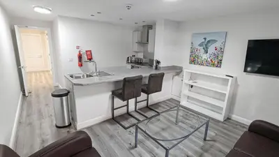 a kitchen with a counter and two chairs in a room at Cocoon @ International Inn + Apartments in Liverpool