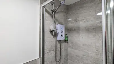 a shower with a glass door in a bathroom at Cocoon @ International Inn + Apartments in Liverpool