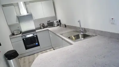 a kitchen with a sink and a microwave at Cocoon @ International Inn + Apartments in Liverpool