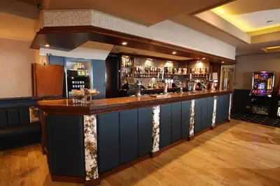 a bar in a pub with a lot of alcohol at Tiffany's Hotel in Blackpool