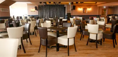 a dining room filled with tables and chairs at Tiffany's Hotel in Blackpool