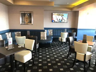 a restaurant with tables and chairs and a tv on the wall at Tiffany's Hotel in Blackpool