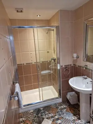 a bathroom with a shower and a sink at Tiffany's Hotel in Blackpool