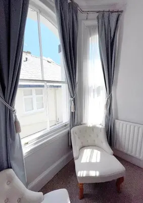 a room with a chair and a window at Dukes Folly Hotel in Southport
