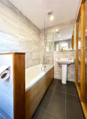 a bathroom with a tub and a sink and a bath tub at Dukes Folly Hotel in Southport