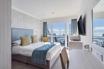 a bedroom with a bed with a view of the ocean at St Ives Hotel in Lytham St Annes