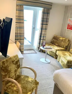 a living room with a couch and a table at St Ives Hotel in Lytham St Annes