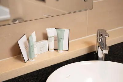 a bathroom counter with three bottles ofodorizers on it at Spa Hotel at Ribby Hall Village in Wrea Green