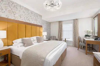 a bedroom with a large bed and a desk at Spa Hotel at Ribby Hall Village in Wrea Green