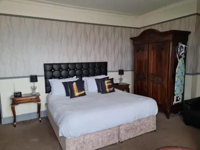 a bedroom with a large bed and a wooden cabinet at Ye Olde Fighting Cocks in Arnside