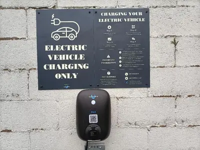 a parking meter attached to a brick wall with a sign at Ye Olde Fighting Cocks in Arnside