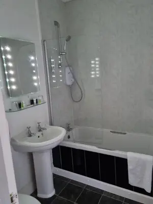 a bathroom with a sink and a shower and a toilet at Ye Olde Fighting Cocks in Arnside