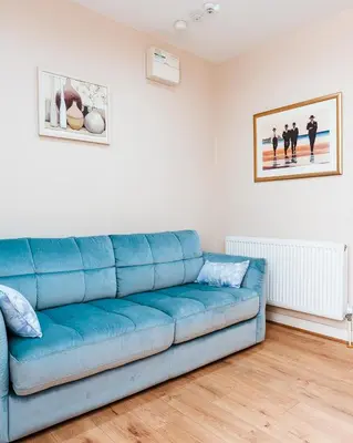 a blue couch sitting in a living room at Kelvin House in Fleetwood