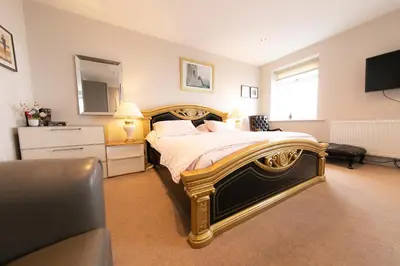 a bedroom with a bed with a mirror and a television at Kelvin House in Fleetwood