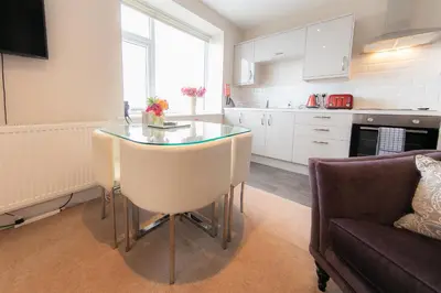a kitchen with a glass table and a couch at Kelvin House in Fleetwood