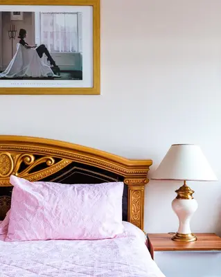a bedroom with a bed with a pink pillow and a lamp at Kelvin House in Fleetwood