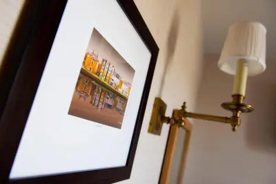a framed picture on a wall next to a lamp at Wagon & Horses in Lancaster