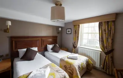 a hotel room with two beds and a window at Wagon & Horses in Lancaster