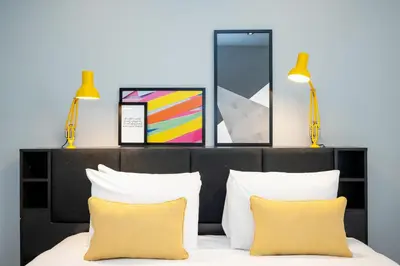 a bedroom with two lamps and a bed with yellow pillows at Staycity Aparthotels Liverpool Waterfront in Liverpool