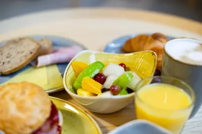 a table with a plate of food and a bowl of fruit at Staycity Aparthotels Liverpool Waterfront in Liverpool