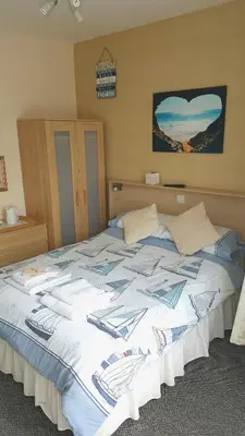 a large bed with a blue and white comforter at The Beverley Hotel in Blackpool