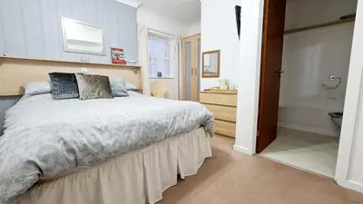 a bedroom with a bed and a bathroom with a sink at The Beverley Hotel in Blackpool
