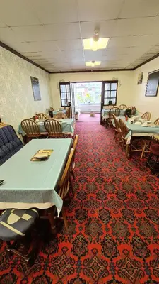a dining room with tables and chairs on a red carpet at The Beverley Hotel in Blackpool
