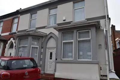 a red car parked in front of a house at Adelaide Apartments 2 in Blackpool