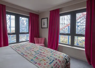 a bedroom with a bed and windows with the eiffel tower at Boulevard Hotel in Blackpool