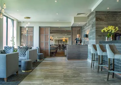 a woman standing at the counter of a restaurant at Boulevard Hotel in Blackpool