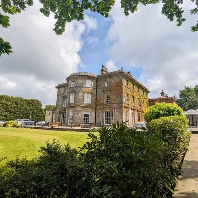 an old brick building in a grassy field at Shaw Hill Hotel Golf And Country Club in Chorley