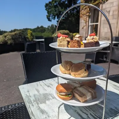 a three tiered tray with different types of food on it at Shaw Hill Hotel Golf And Country Club in Chorley