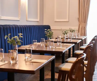a row of wooden tables with wine glasses on them at Shaw Hill Hotel Golf And Country Club in Chorley