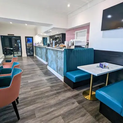 a restaurant with a counter and a table and chairs at Shaw Hill Hotel Golf And Country Club in Chorley