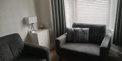 a living room with two chairs and a lamp at 39 Cowley Road in Liverpool