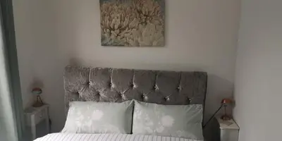 a bed with a gray head board with two pillows at 39 Cowley Road in Liverpool
