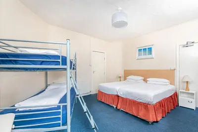 a bedroom with two bunk beds and a ladder at Sandpiper Holiday Apartments in Blackpool