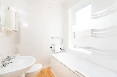 a white bathroom with a sink and a toilet at Sandpiper Holiday Apartments in Blackpool