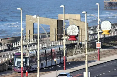 a train on a road next to the ocean at Sandpiper Holiday Apartments in Blackpool