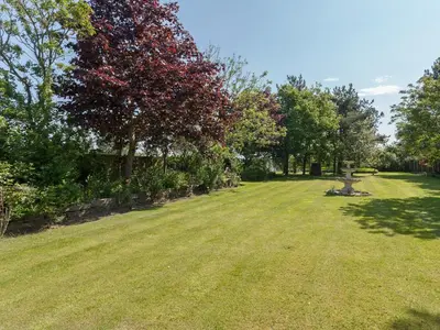 a park with a bench in the middle of a field at Buttercup Cottage in Halsall