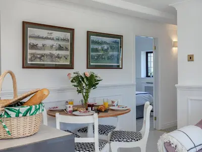 a living room with a table and chairs and a dining room at Buttercup Cottage in Halsall