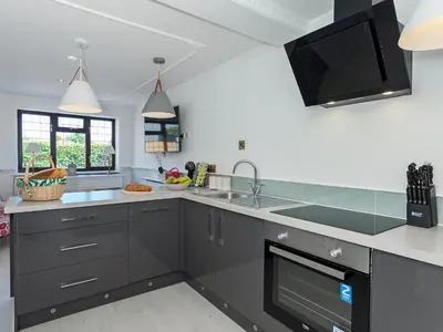 a kitchen with gray cabinets and a sink at Buttercup Cottage in Halsall