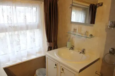 a bathroom with a sink and a mirror and a window at Mardonia Hotel in Blackpool