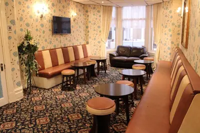 a waiting room with tables and a couch at Mardonia Hotel in Blackpool