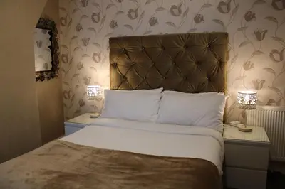 a bedroom with a bed and two night stands with lamps at Mardonia Hotel in Blackpool