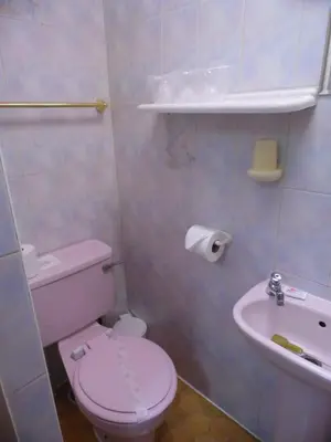 a small bathroom with a toilet and a sink at St Albans Hotel in Blackpool